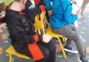 Dzieci z grupy fioletowej w przebraniach karnawałowych biorą udział w konkursie "wolne krzesełko"