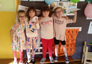 Na zdjęciu 4 dziewczynki pozują na tle klasowej tablicy przybranej w balony, dziewczyny się uśmiechają
