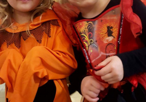 Na zdjęciu dwie dziewczynki przebrane w pomarańczowe jesienne stroje