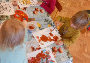 Dzieci malują farbami rysunek misia.