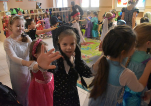 Na zdjęciu dziewczynki z grupy czerwonej bawią się w wężyka jedna z dziewczynek macha do zdjęcia