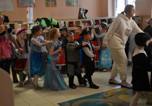 Na zdjęciu dzieci przebrane w stroje karnawałowe tańczą wraz z Paniami przebranymi w stroje
