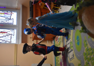Na zdjęciu dzieci z grupy fioletowej tańczą w kółeczku dzieci są przebrane w stroje karnawałowe