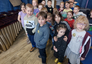 Dzieci z grupy czerwonej podczas wycieczki do Szkoły muzycznej dzieci stoją w sali z instrumentami