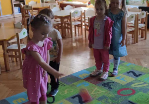 Na zdjęciu dzieci z grupy zielonej podczas obchodów Dnia przedszkolaka dzieci bawią się na dywanie w tor przeszkód jedna z dziewczynek wskazuje na kolejną przeszkodę
