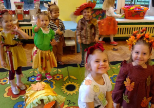 Na zdjęciu dzieci z grupy żółtej dzieci stoją na dywanie dzieci są przebrane stroje o tematyce jesiennej