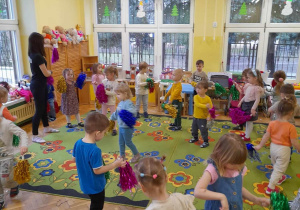 Na zdjęciu dzieci z grupy żółtej z pomponami w różnych kolorach, dzieci tańczą