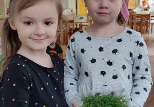 Na zdjęciu dwie dziewczynki z pojemnikiem z wyrośniętą rzeżuchą