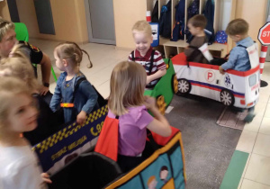 Na zdjęciu dzieci z grupy żółtej przebrani w samochody poruszają się po przygotowanej wykładzinie