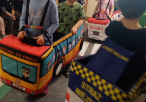 Na zdjęciu dzieci z grupy żółtej przebrani w samochody poruszają się po przygotowanej wykładzinie