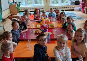 Na zdjęciu dzieci z grupy czerwonej podczas jedzenia przysmaków z pikniku, dzieci siedzą przy stole