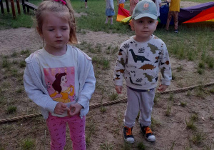 Na zdjęciu dwoje dzieci dziewczynka i chłopiec bawią się w ogrodzie przedszkolnym