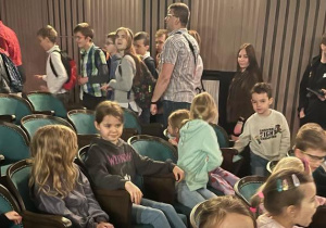 Na zdjęciu dzieci z grupy zielonej i czerwonej siedzą na widowni