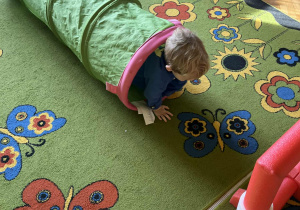 Na zdjęciu chłopcy przechodzący przez tunel