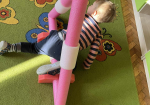 Na zdjęciu dziewczynka przechodząca przez tor przeszkód