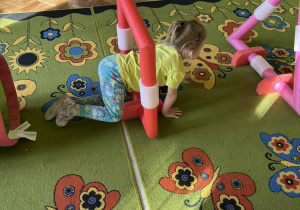 Na zdjęciu dziewczynka przechodząca przez tor przeszkód