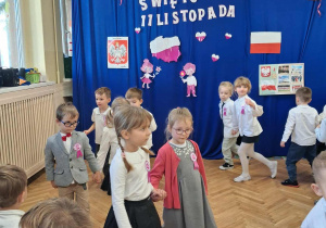 Na zdjęciu dzieci z grupy czerwonej, dzieci ubrane na galowo tańcz taniec polonez