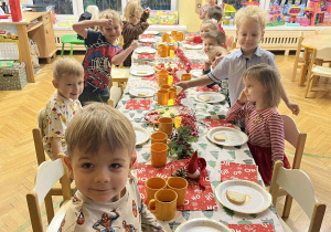 Na zdjęciu dzieci siedzą przy przystrojonym stole, dzieci jedzą wspólnie śniadanie mikołajkowe