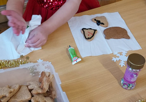 Na zdjęciu dziewczynka ozdabiająca pierniki