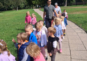 Dzieci idą parami na spacer do parku