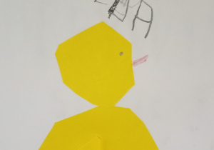 Na zdjęciu praca wykonana przez Helenkę z grupy pomarańczowej, na białej kartce żółty kurczak z papieru
