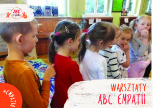 Zdjęcie grupy czerwonej dzieci stoją ustawione jedno za drugim rysują sobie coś na plecach na dole zdjęcia napis Warsztaty ABC Empatii