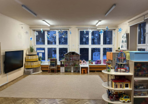 Na zdjęciu grupa pomarańczowa, na fotografii widać dywan i meble z zabawkami oraz sprzęt multimedialny