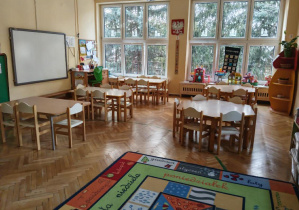 Na zdjęciu grupa czerwona, na zdjęciu stoły z krzesłami dywan, tablica multimedialna